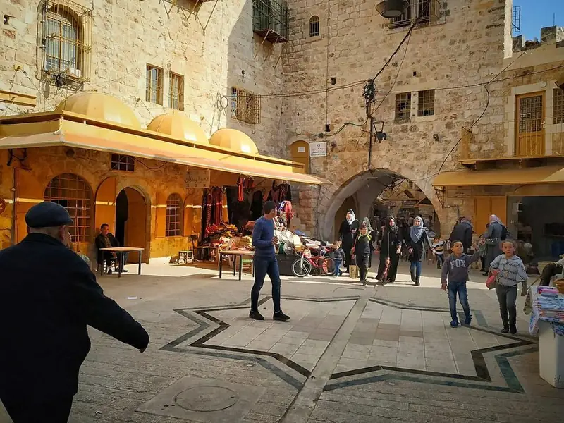 People in the stone square of Hebron’s old souq.